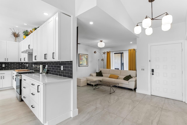 kitchen with under cabinet range hood, light countertops, decorative backsplash, stainless steel electric range oven, and open floor plan