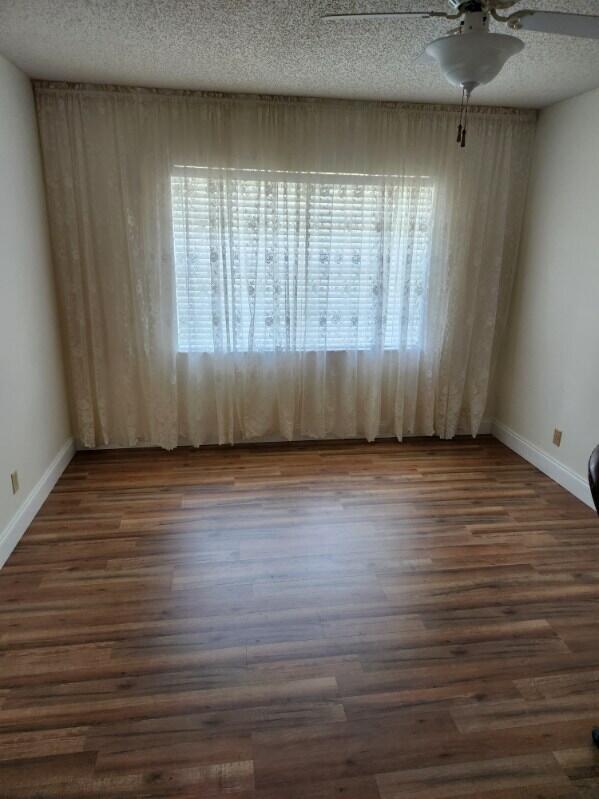 625 Pines Knoll Dr Unit B, Fort Pierce, FL 34982 - unfurnished room featuring baseboards, a textured ceiling, ceiling fan, and dark wood finished floors