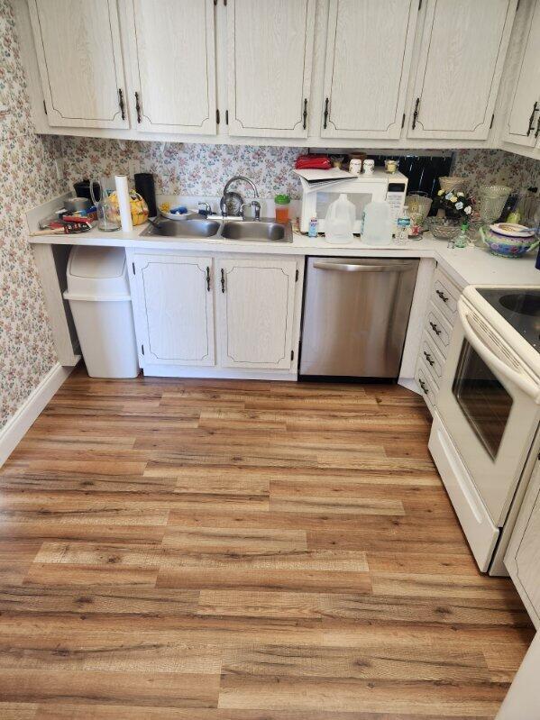 625 Pines Knoll Dr Unit B, Fort Pierce, FL 34982 - kitchen with wallpapered walls, white range with electric stovetop, light countertops, dishwasher, and a sink