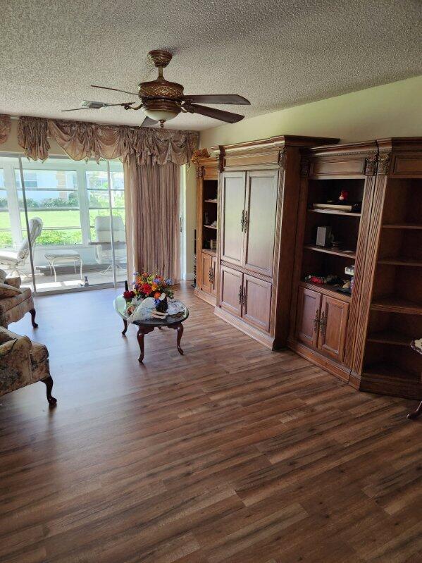 625 Pines Knoll Dr Unit B, Fort Pierce, FL 34982 - living area with dark wood finished floors, a textured ceiling, and a ceiling fan