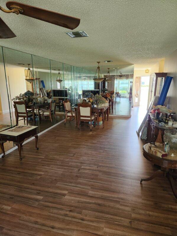 625 Pines Knoll Dr Unit B, Fort Pierce, FL 34982 - dining area featuring wood finished floors, a textured ceiling, and visible vents