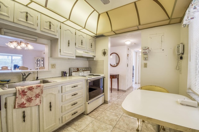 4281 NW 41st St Unit 320, Lauderdale Lakes, FL 33319 - kitchen with electric stove, under cabinet range hood, a sink, decorative backsplash, and light countertops
