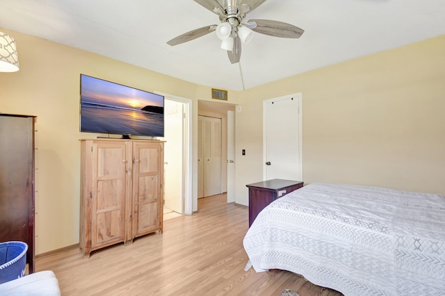 bedroom with a ceiling fan, baseboards, visible vents, and light wood finished floors