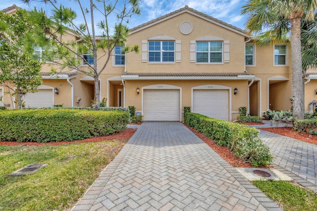 5797 Monterra Club Dr, Lake Worth, FL 33463 - view of property featuring stucco siding, an attached garage, and decorative driveway
