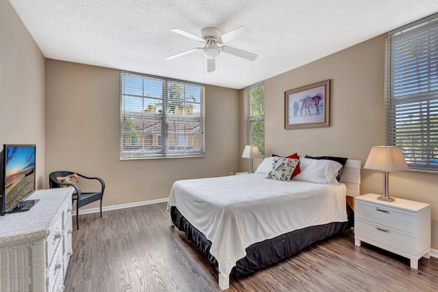 11760 Saint Andrews Pl Unit 204, Wellington, FL 33414 - bedroom featuring baseboards, wood finished floors, a textured ceiling, and ceiling fan