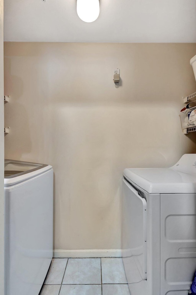 11760 Saint Andrews Pl Unit 204, Wellington, FL 33414 - clothes washing area with washing machine and dryer, baseboards, light tile patterned floors, and laundry area