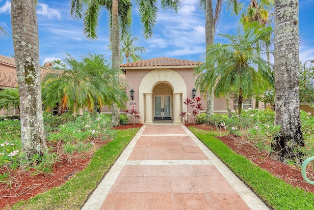 11760 Saint Andrews Pl Unit 204, Wellington, FL 33414 - view of front facade featuring a tiled roof, french doors, and stucco siding