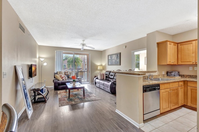 11760 Saint Andrews Pl Unit 204, Wellington, FL 33414 - kitchen with a sink, a textured ceiling, open floor plan, visible vents, and dishwasher