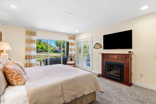 bedroom featuring carpet floors, baseboards, a glass covered fireplace, and access to exterior