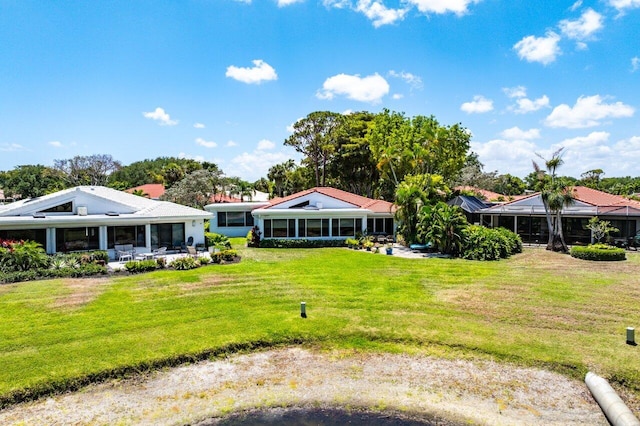 rear view of house with a yard and a sunroom