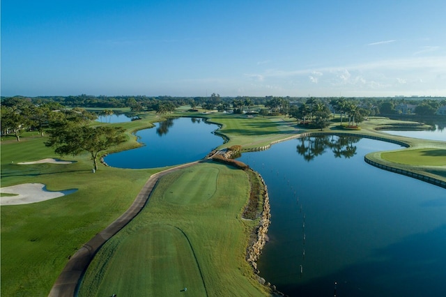 drone / aerial view with view of golf course and a water view