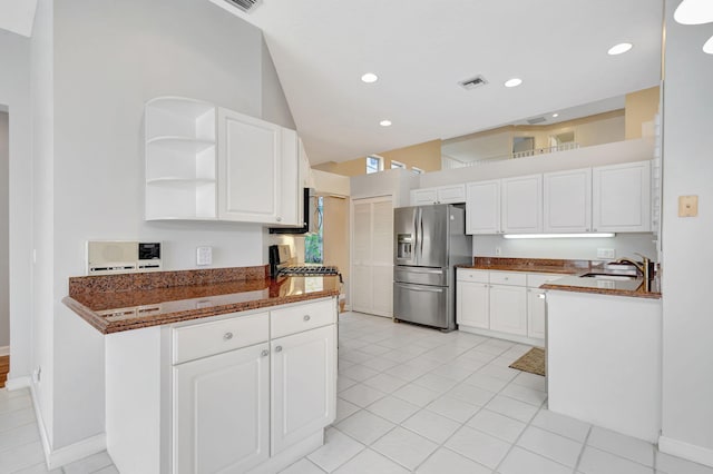 kitchen featuring white cabinetry, stainless steel fridge, visible vents, and a sink