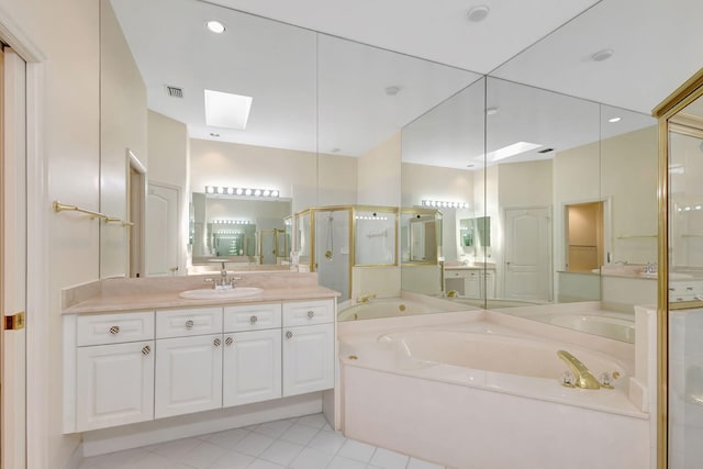bathroom with a skylight, vanity, visible vents, a shower stall, and a garden tub