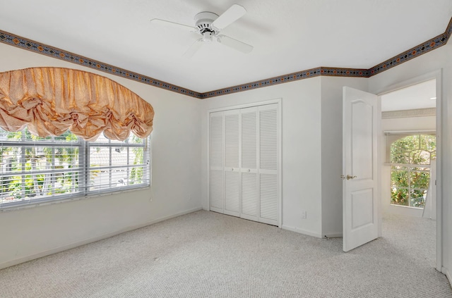 unfurnished bedroom with multiple windows, a closet, baseboards, and carpet