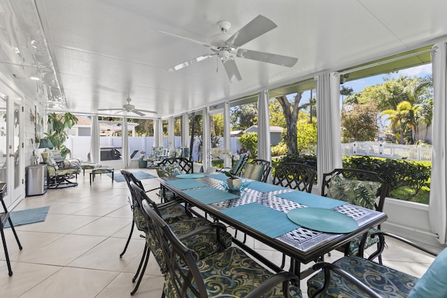 sunroom featuring outdoor dining area, ceiling fan, and a healthy amount of sunlight