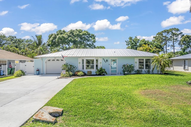 single story home featuring driveway, metal roof, a front yard, and a garage
