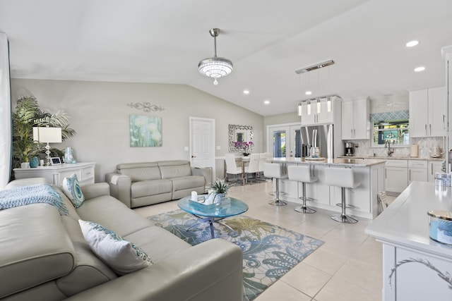 living room featuring recessed lighting, vaulted ceiling, and light tile patterned floors