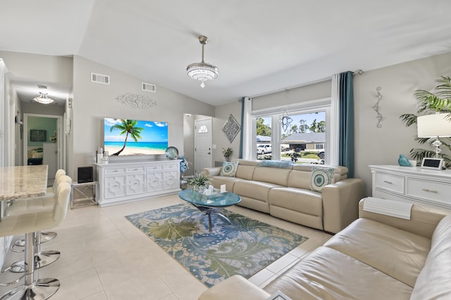 living area with vaulted ceiling, visible vents, and light tile patterned floors