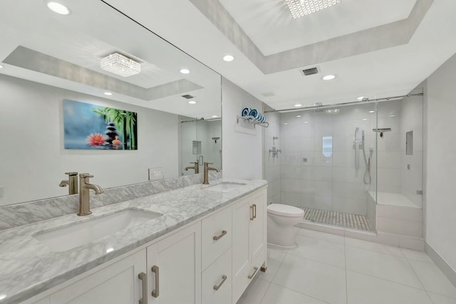 full bath featuring a tray ceiling, a shower stall, tile patterned floors, and a sink