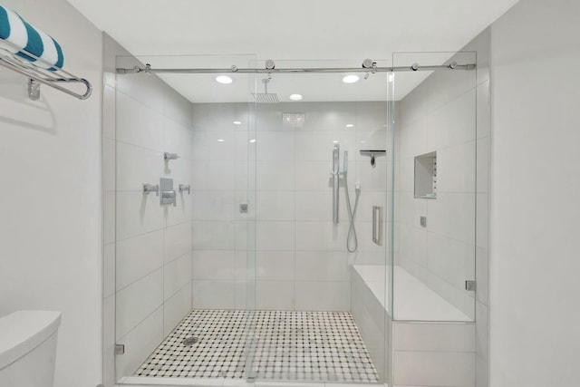 bathroom featuring toilet and a stall shower
