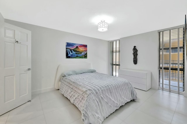 bedroom featuring light tile patterned flooring and baseboards