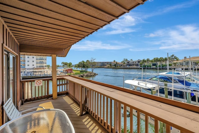 balcony with a water view and a dock
