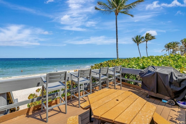 deck with a view of the beach, a water view, and a grill