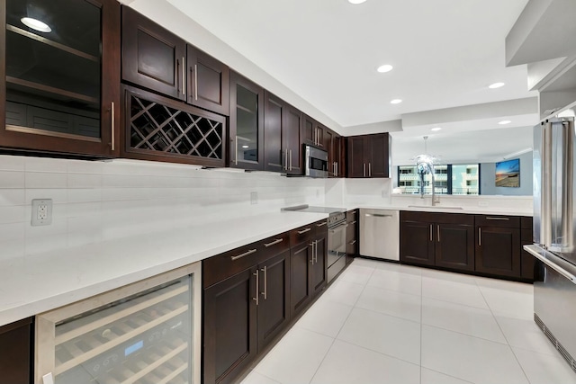 bar featuring recessed lighting, beverage cooler, a sink, light tile patterned flooring, and appliances with stainless steel finishes