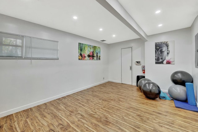 exercise room with baseboards, wood finished floors, visible vents, and recessed lighting