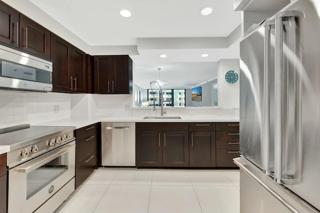 kitchen with light countertops, dark brown cabinets, appliances with stainless steel finishes, and a sink