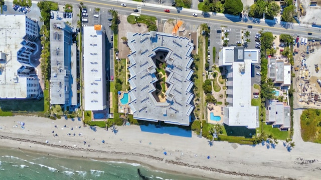 birds eye view of property featuring a beach view and a water view