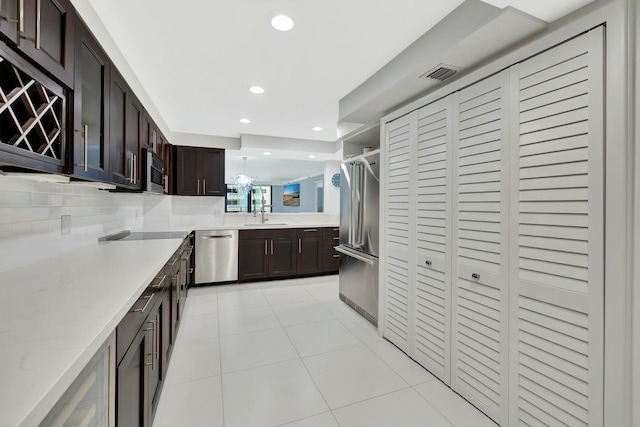 kitchen with stainless steel appliances, a sink, visible vents, dark brown cabinetry, and recessed lighting