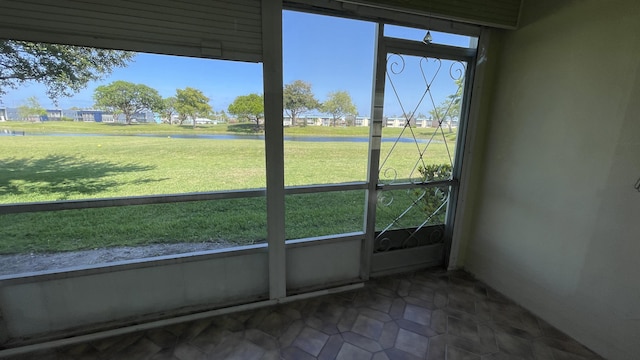 unfurnished sunroom with a water view
