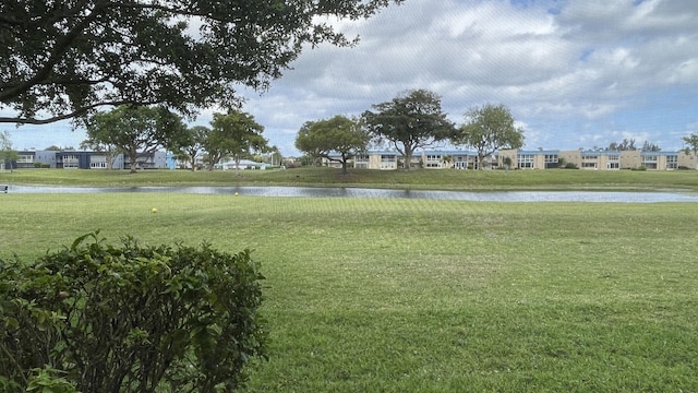 view of home's community with a yard and a water view