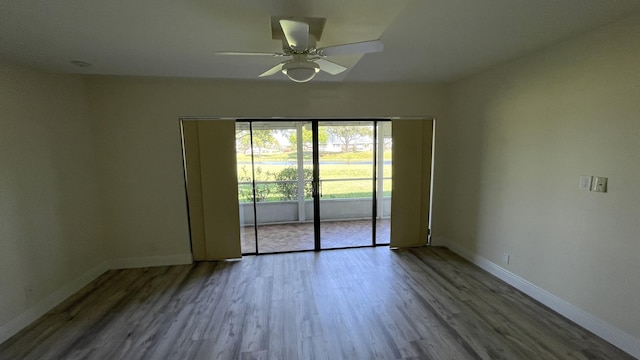 unfurnished room featuring baseboards, wood finished floors, and a ceiling fan