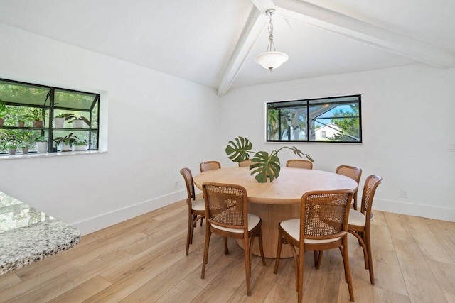 dining room with light wood finished floors, plenty of natural light, lofted ceiling with beams, and baseboards