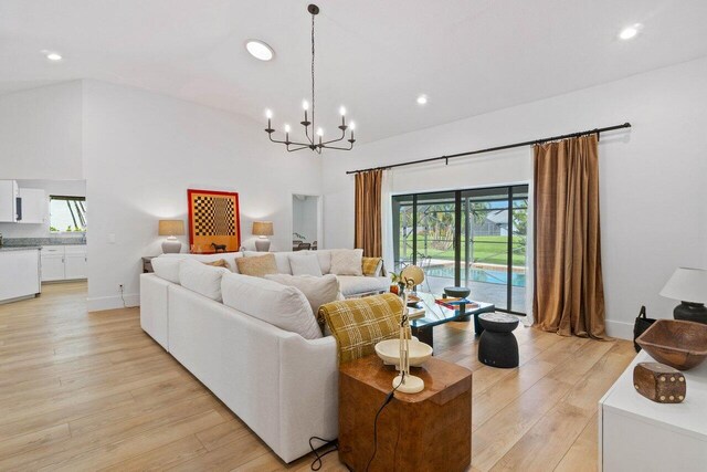 living area featuring recessed lighting, light wood-type flooring, plenty of natural light, and an inviting chandelier