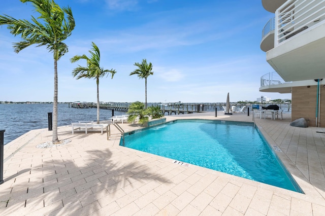 pool with a patio area and a water view