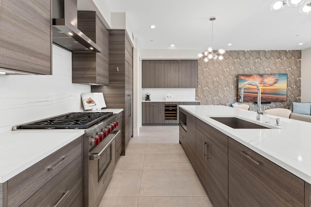 kitchen with wall chimney range hood, a sink, stainless steel range, light tile patterned floors, and modern cabinets