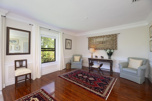 sitting room with ornamental molding, wood finished floors, a wainscoted wall, and a decorative wall