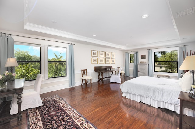 bedroom with a raised ceiling, wood finished floors, ornamental molding, and recessed lighting