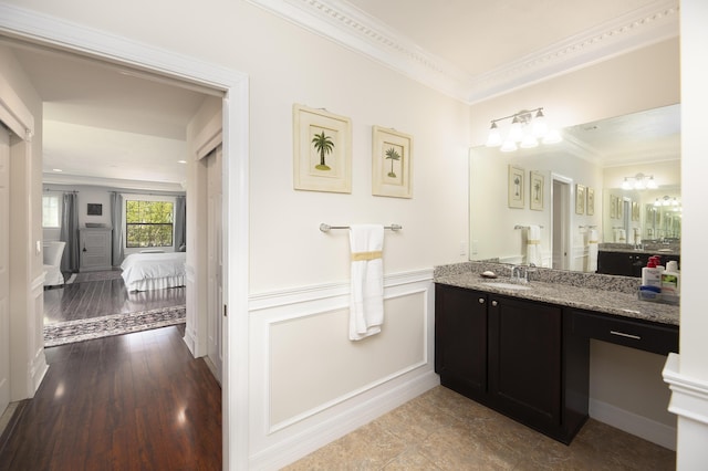 bathroom with crown molding, vanity, and connected bathroom