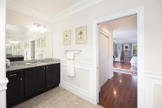 ensuite bathroom with crown molding and vanity