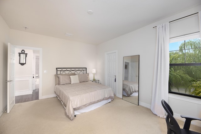 bedroom featuring light colored carpet and baseboards