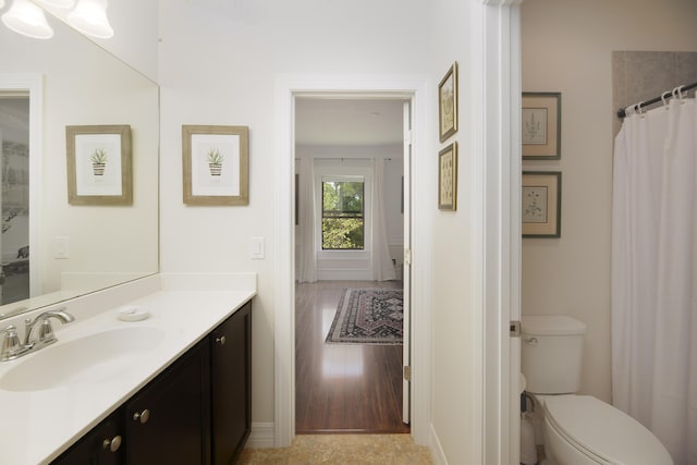 full bath with vanity, toilet, baseboards, and wood finished floors