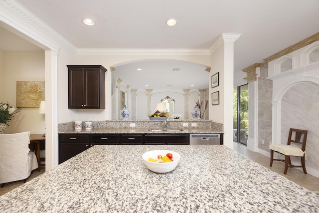 kitchen with ornate columns, dishwasher, a sink, dark brown cabinetry, and light stone counters