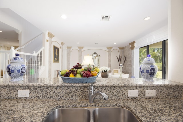 kitchen featuring a sink, stone counters, and recessed lighting