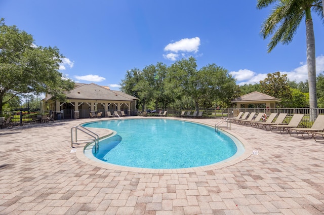 community pool featuring fence and a patio area