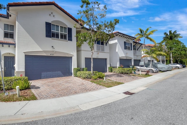 4721 N Prive Cir, Delray Beach, FL 33445 - view of front facade featuring an attached garage, stucco siding, decorative driveway, and a tiled roof
