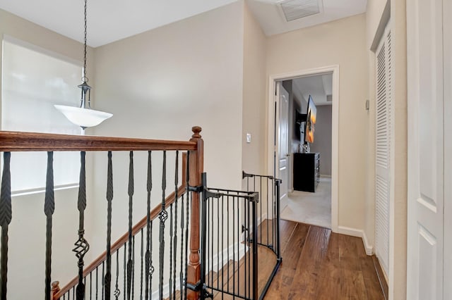 4721 N Prive Cir, Delray Beach, FL 33445 - hallway featuring visible vents, baseboards, wood finished floors, and an upstairs landing